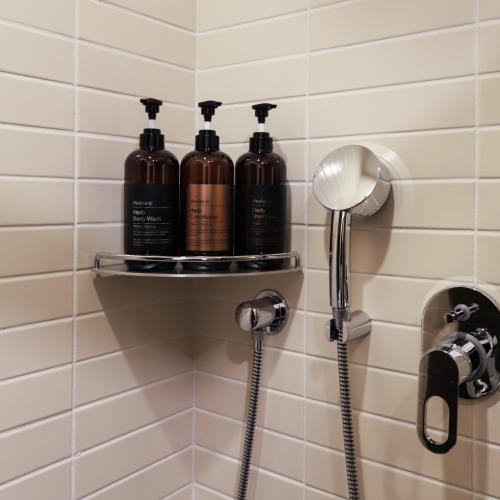 a bathroom with three shampoo bottles on a shelf at LE SEOUL HOTEL in Seoul