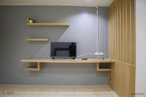 a desk with a computer on a wall at ดีลิฟวิ่ง เพลส มหาสารคาม in Maha Sarakham