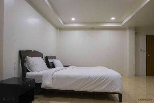 a bedroom with a bed with white sheets and pillows at ดีลิฟวิ่ง เพลส มหาสารคาม in Maha Sarakham