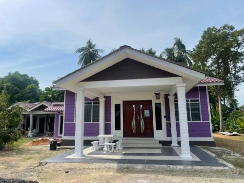 MerlimauにあるAR HOMESTAY & ROOMESTAYの赤い扉付小紫色の家