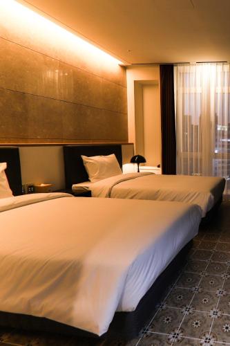 a hotel room with two beds and a window at LE SEOUL HOTEL in Seoul