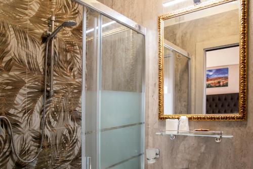 ein Bad mit einer Dusche und einem Spiegel in der Unterkunft Hotel Merlini in Florenz