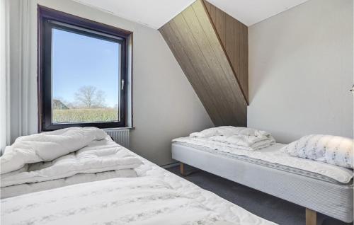 Stunning Home In Nordborg With Kitchen في نُوابورغ: سريرين في غرفة مع نافذة