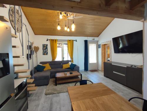 ein Wohnzimmer mit einem Sofa und einem Tisch in der Unterkunft Les Gentianes, Appartement au pied des pistes in Saint-Pierre-dels-Forcats