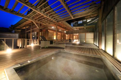 una piscina coperta in un edificio con terrazza in legno di Fuji Onsenji Yumedono a Fujikawaguchiko