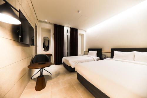 a hotel room with two beds and a television at LE SEOUL HOTEL in Seoul