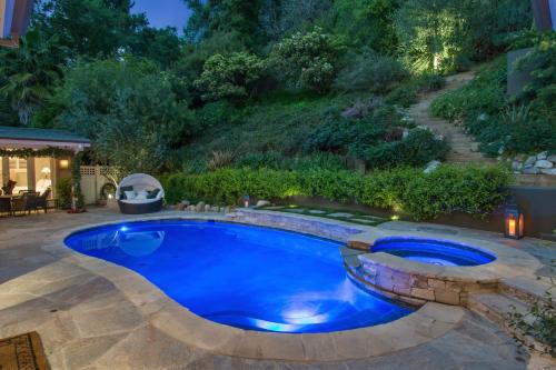 a swimming pool in a backyard at night with a landscaping at Luxury Beverly Hills Suite in Beverly Hills