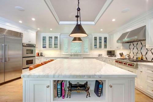 a large white kitchen with a large island in the middle at Luxury Beverly Hills Suite in Beverly Hills