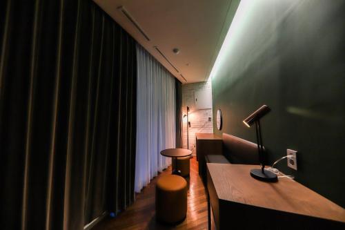 a room with a couch and a desk with a lamp at LE SEOUL HOTEL in Seoul