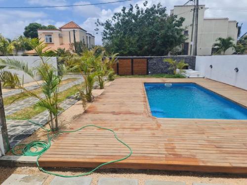 a wooden deck next to a swimming pool with a hose at Silverwood in Pereybere
