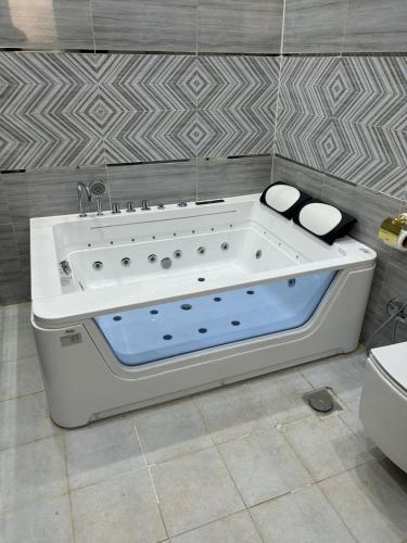 شقة متكاملة غرفتين مع جاكوزي في الرياض: حوض استحمام أبيض جالس في الحمام
