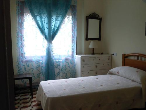a bedroom with a bed and a window with a dresser at El molino de Foz Calanda in Foz-Calanda