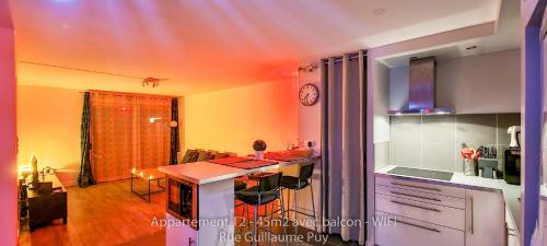 une cuisine avec un comptoir et une table avec des chaises dans l'établissement Les Arcades - WIFI - Intra muros of Avignon - Balcony - 45m2, à Avignon