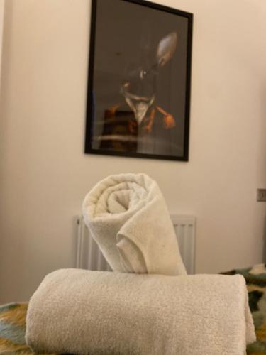 a pile of towels sitting on top of a bed at Salt Life Contemporary Apartment in Brighton & Hove