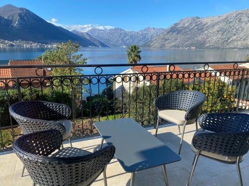 a table and chairs on a balcony with a view of the water at 2montenegro MIMOZA Apartments in Dobrota