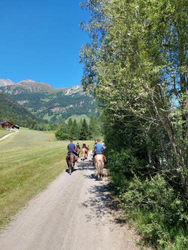 a group of people riding horses down a dirt road at Apartment Haus Christina in Großkirchheim