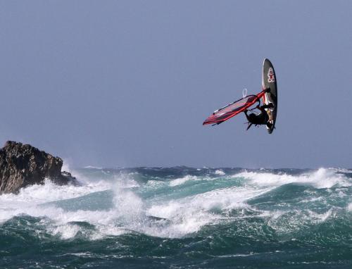 a man flying through the air on a surfboard in the ocean at FILAO EDEN SAKALAVA in Antsiranana