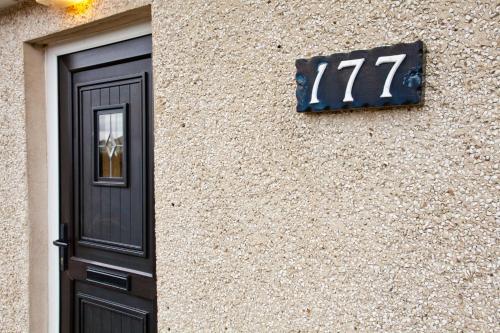 a building with a door and a clock on it at Branch cottage in Limavady