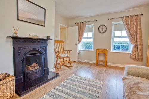 a living room with a fireplace and a couch at Branch cottage in Limavady