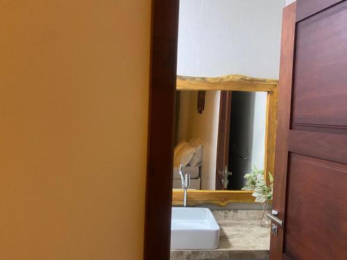 a bathroom with a sink and a mirror at Pousada Águas de Tamandaré in Tamandaré