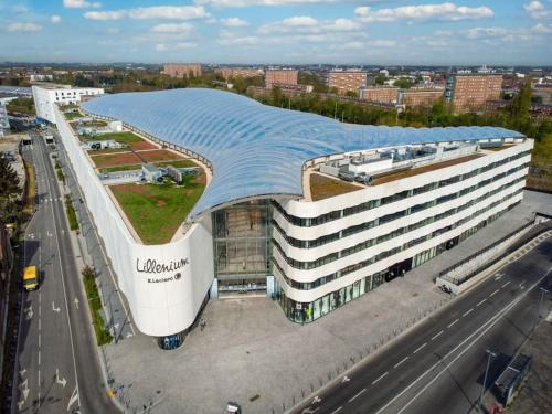 a large building with a curved roof on a street at pourquoi notre T3 avec parking est pour vous ? in Lille