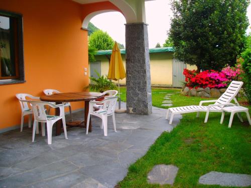 patio con tavolo, sedie e ombrellone di Appartamenti Girasole a Cannobio