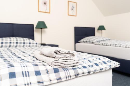 two beds with towels sitting on them in a room at Penzion Grado Davle in Davle