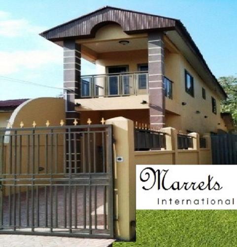 a house with a gate in front of it at Marrets International Hotel - "Express" in Cape Coast