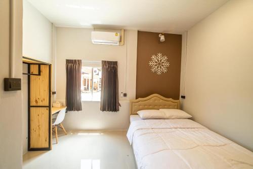 um quarto com uma cama, uma secretária e uma janela em J Villa Betong - Private House em Betong