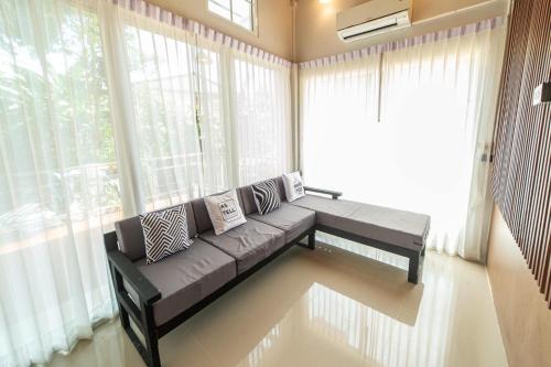 a living room with a couch in front of a window at J Villa Betong - Private House in Betong