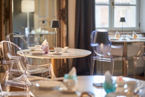 a restaurant with chairs and tables with cups and saucers at B&B Le Logge Luxury Rooms in Siena
