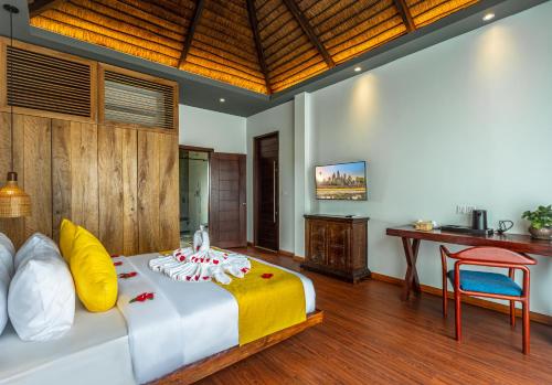 a bedroom with a large bed and a desk at Le Chanthou Boutique in Siem Reap