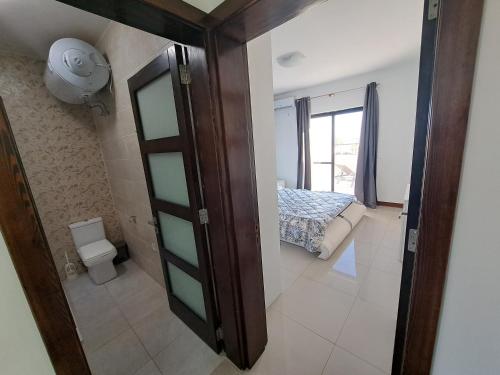 een badkamer met een deur naar een slaapkamer bij Sea view penthouse in Żebbuġ