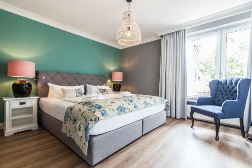 um quarto com uma cama e uma cadeira azul em Ferienwohnung Hus up Höcht em Langeoog