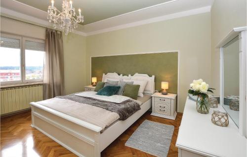 Un dormitorio con una cama grande y una lámpara de araña. en Awesome Home In Sezana With Outdoor Swimming Pool en Sežana