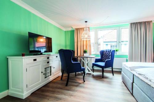 ランゲオークにあるLieblingsinsel Langeoogの緑の壁のベッドルーム(テーブル、椅子付)
