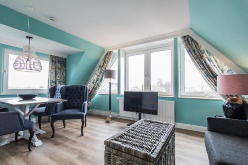 a living room with blue walls and a table and a tv at Lieblingsinsel Langeoog in Langeoog