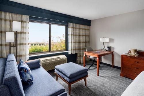 ein Hotelzimmer mit einem Sofa, einem Schreibtisch und einem Fenster in der Unterkunft Courtyard by Marriott Sacramento Folsom in Folsom