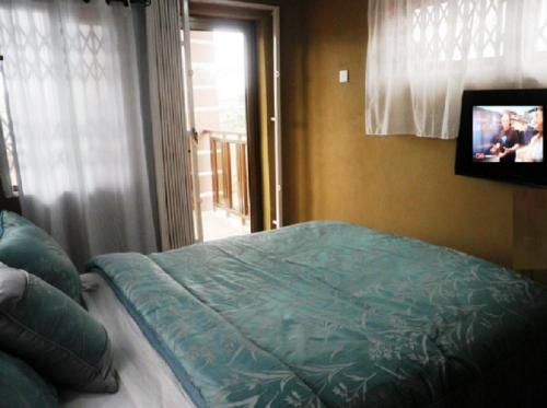 a bedroom with a bed with a television and a window at Marrets International Hotel - "Express" in Cape Coast