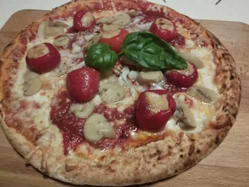 a pizza with pepperoni and basil on a wooden table at Dogs baronesse Pasja grofica Idrija in Idrija