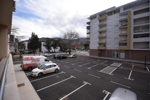 a parking lot with a white car and a van at Apartman Allena Trebinje in Trebinje