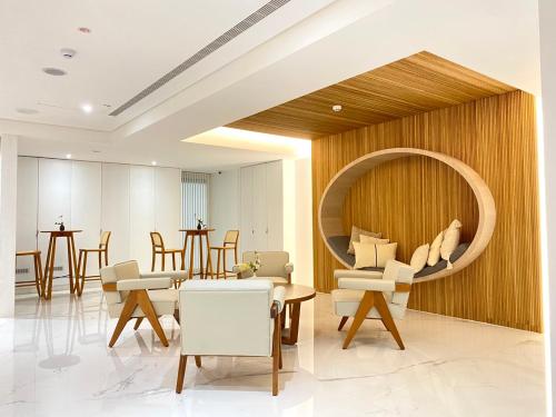 vestíbulo con espejo redondo, sillas y mesas en suye hotel, en Taichung