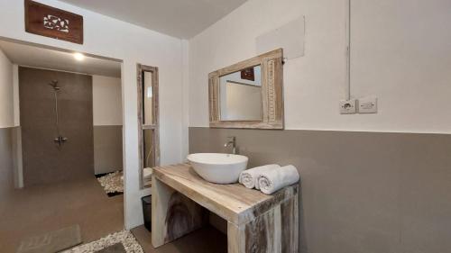 a bathroom with a white sink and a mirror at Peraja Bungalows Loyok in Sangyang