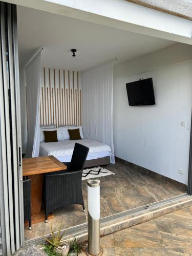 een kamer met een bed, een bureau en een televisie bij Suite by the Pool in Faaa