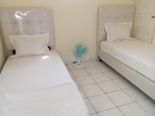 een kamer met 2 bedden en een ventilator bij Balqis Homestay Syariah II Pasar Aur Kuning in Bukittinggi
