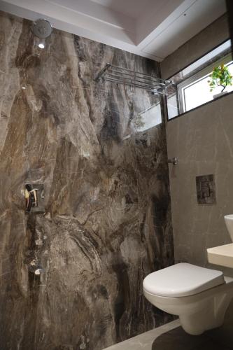 bagno con servizi igienici e parete di roccia. di Vishal Hall a Mumbai