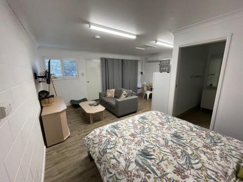 a bedroom with a bed and a couch in a room at Studio Apartment in East Toowoomba in Toowoomba