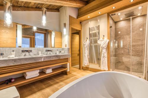 a bathroom with a large tub and a glass shower at Rock and Stars Megève in Megève