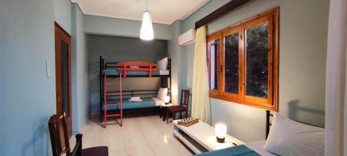ネア・アンヒアロスにあるAnchialos seafront appartementの二段ベッド1組、デスクが備わる小さな客室です。