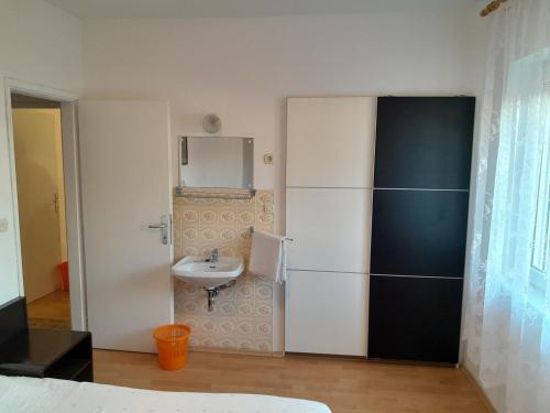 a small bathroom with a sink and a mirror at Apartments Josip 2830 in Rab